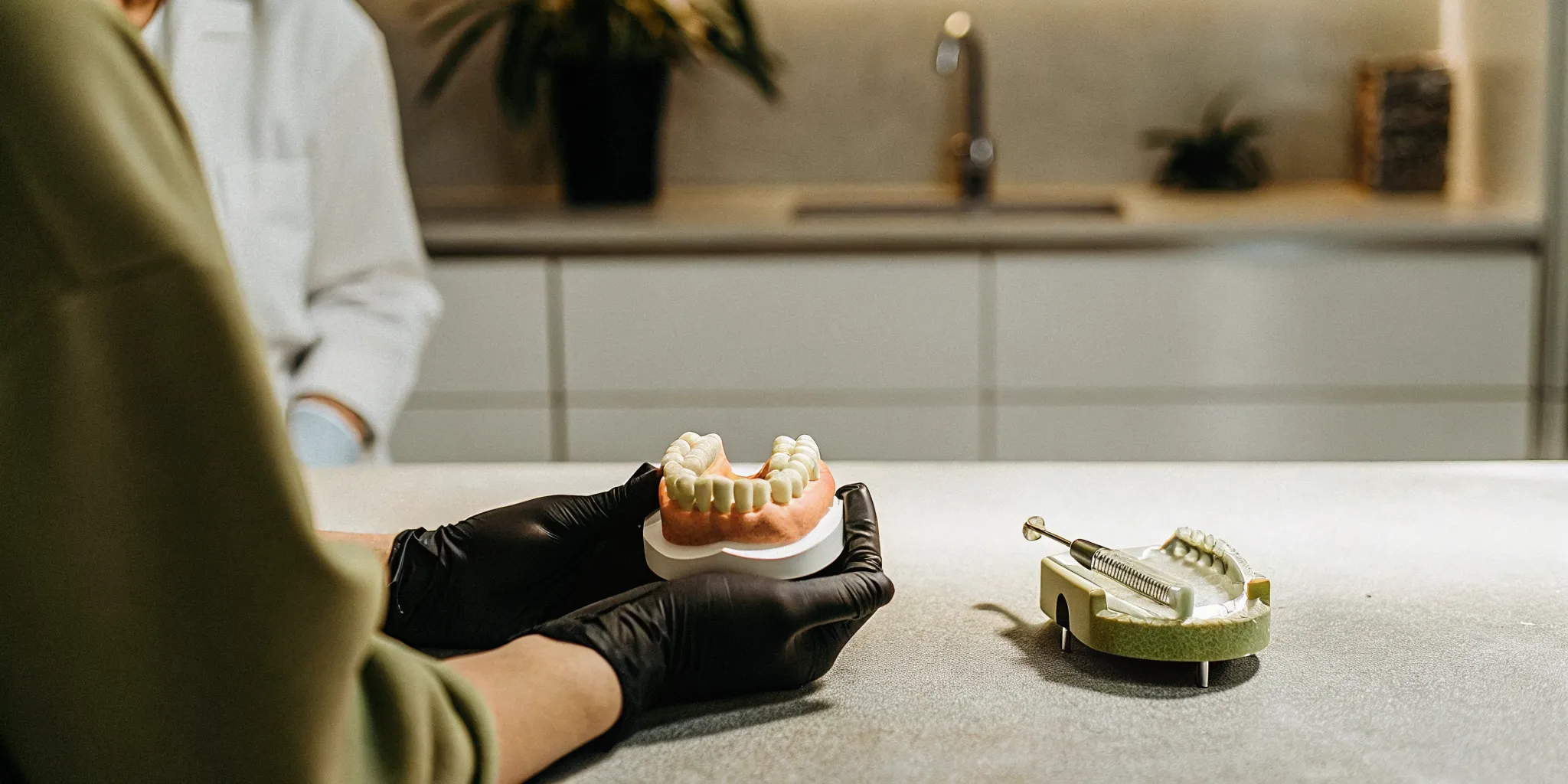 Prosthodontist specialist holding a model of All-on-4 dentures.